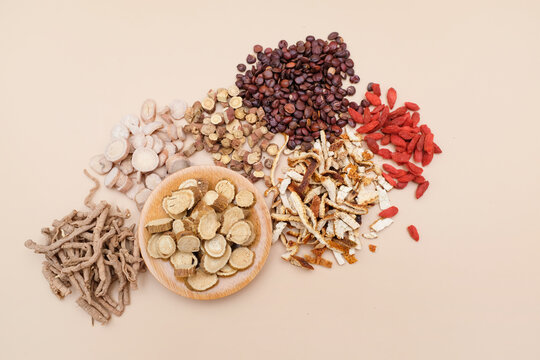 A variety of dried and sliced traditional Chinese medicinal herbs arranged on a neutral background
