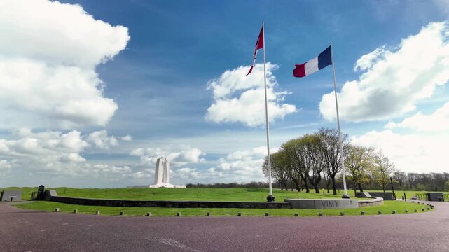 The Canadian National Vimy Memorial stands tall against a blue sky, honoring WWI soldiers in a serene setting.