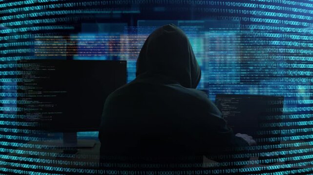 Cyber Hacker Activity. Shadowy Person Monitoring Systems Through Glow Of Multiple Monitors And Code