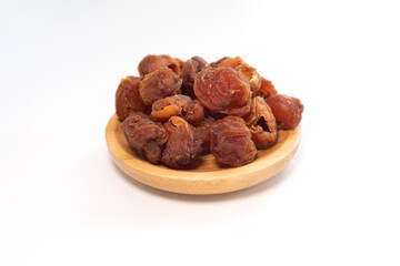 Obraz premium Dried longan fruits presented on a small wooden dish in close-up shot