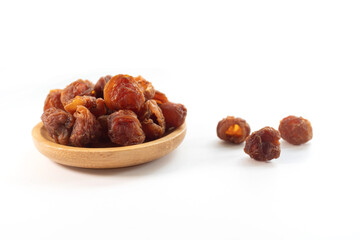 Obraz premium Dried longan fruits in a wooden bowl captured in close-up still life photography