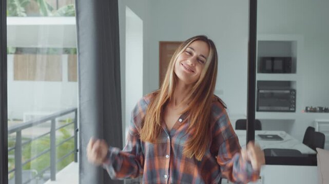 happy girl enjoying good news at home smiling and expressing pure joy and excitement in modern interior. happy girl reacting emotionally to success feeling happiness and positive energy indoors