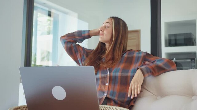 anxious woman working on laptop at home feeling worried and thinking about problem. concerned woman analyzing negative information online in modern apartment