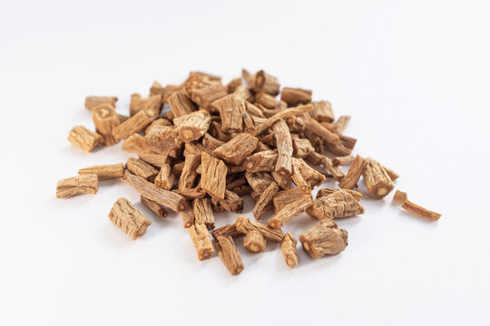 Dried bupleurum root slices piled up in close-up on white background