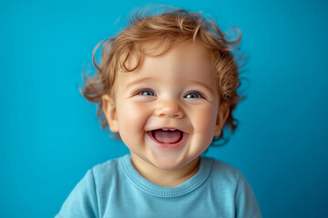 Naklejka premium little boy on a blue background. boy smiling