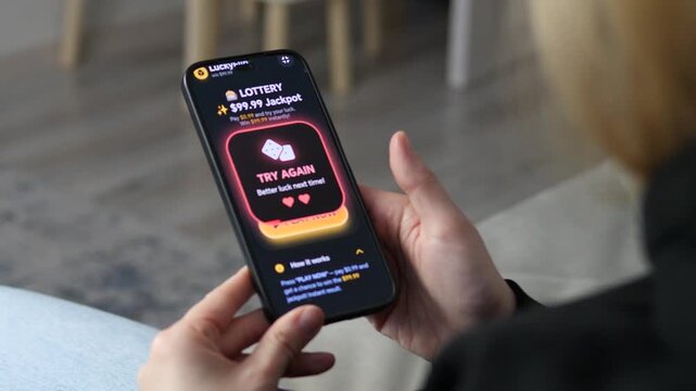 Close-up of a user playing an online lottery on a smartphone. The screen displays a Try Again message after a loss. Ideal for content about mobile gambling, app design, digital gaming trends, and
