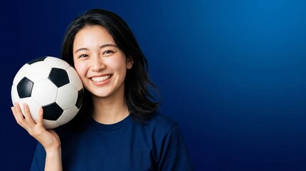 Obraz premium サッカーボールを頬に寄せて笑顔を浮かべている日本人女性