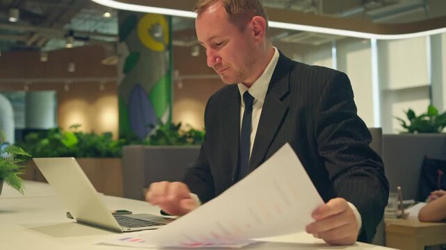 Business professional analyzing reports in modern office environment corporate workspace focused perspective