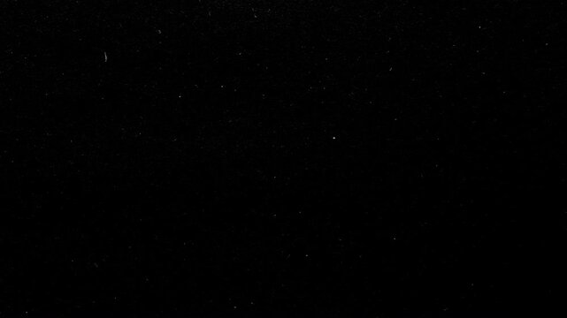 Fast Dust Particles on Black Background. Video of rapid flickering dust, dots and scratches on dark flickering surface.
