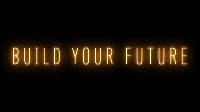 The phrase BUILDYOURFUTURE illuminated in bright orange neon text, centrally placed on a dark black background with a noticeable radiant glow around each letter and a soft light