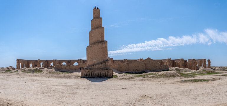 A striking minaret, built with layered brickwork, commands attention against the vibrant blue sky in Abu Dulaf, Iraq