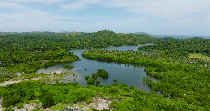 Agmanic Lake and mountain with coconut trees in Santa Fe, Tablas, Romblon. Philippines.