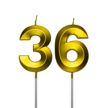 A pair of shiny golden birthday candles in the shape of the number thirty six, featuring a spiral textured surface and isolated on a plain white background.
