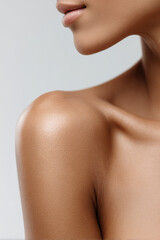 Naklejka premium Skincare branding close-up of woman shoulder and lips, smooth glowing skin on neutral studio background