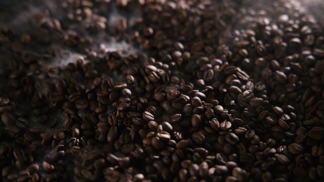 Roasting process of coffee beans with smoke, dark light.