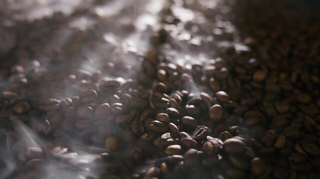 Freshly roasted brown coffee beans cooling and stirring process showcased in dynamic sequence.
