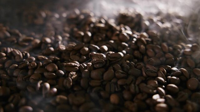 Coffee beans with smoke roasting process in roaster machine.