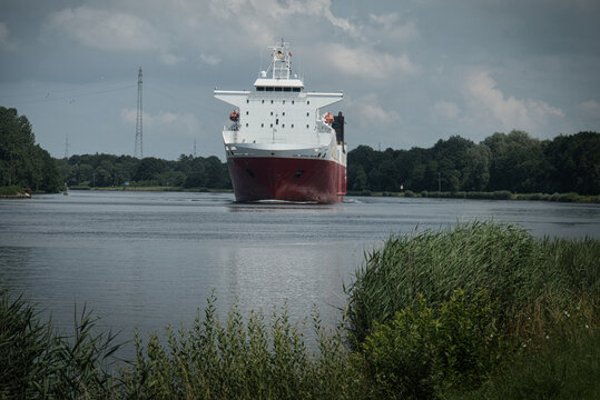 Gro&szlig;es Frachtschiff auf dem Nord-Ostsee-Kanal zwischen gr&uuml;nen Uferlandschaften