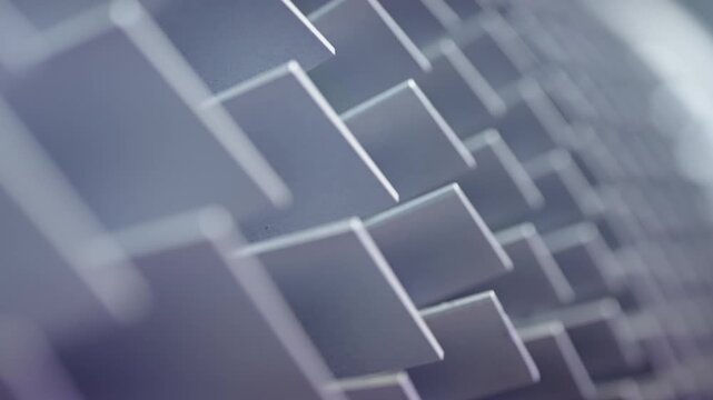 Macro close-up of staggered metallic square panels forming an abstract geometric pattern, captured with shallow depth of field and gradient lighting along a diagonal angle