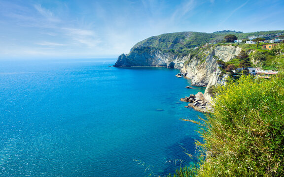 Scenic view of Mediterranean coast with steep cliffs on Ischia island. Deep turquoise sea water meets rocky shoreline near Sant'Angelo village. Summer landscape shows beauty of Ischia coast in Italy
