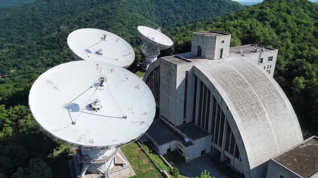 Aerial View of a Remote Satellite Dish Array in a Lush Green Mountainous Landscape.