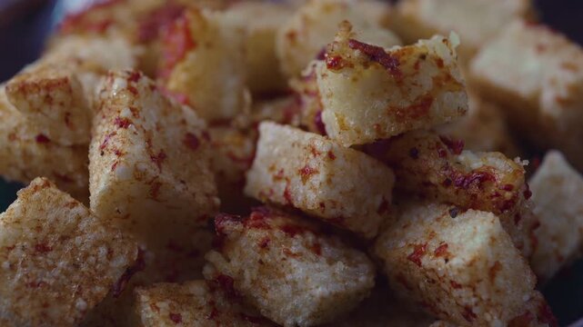 Close up of crispy golden dadinho de tapioca cubes with textured surface and seasoning, capturing traditional Brazilian food, appetizing detail, and rich homemade cooking moment