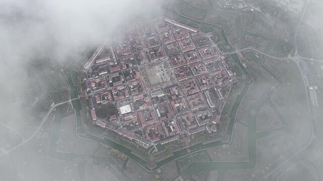 Aerial view of a city blanketed by a thick layer of fog, obscuring details and creating a soft, muted landscape, Neuf-Brisach, Grand Est, France.