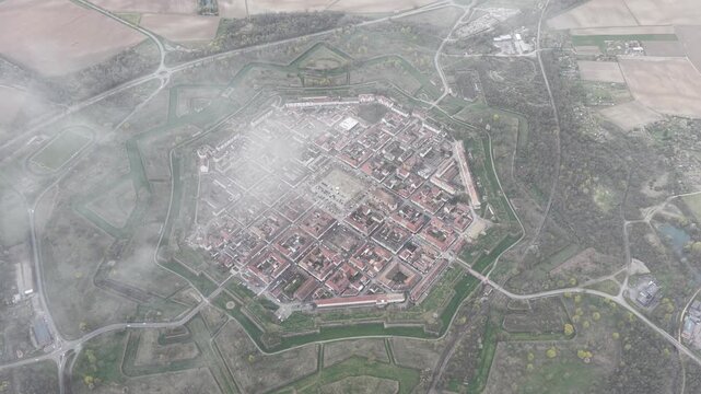 Aerial view of the star-shaped historic fortress of Neuf-Brisach, with its red-roofed buildings and surrounding green fields, Neuf-Brisach, Grand Est, France.