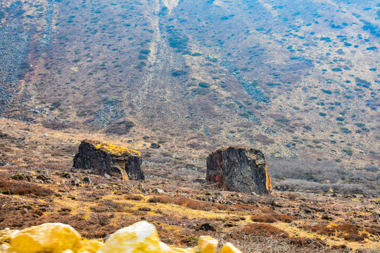 Rocky alpine terrain with scattered boulders and barren slopes in high altitude Himalayan landscape of North Sikkim.