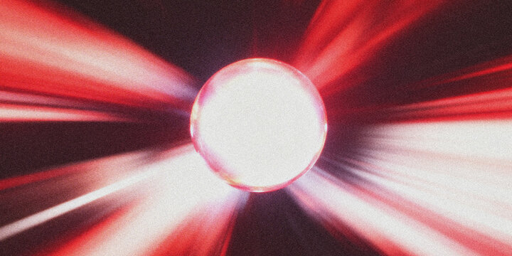 A bright light with red rays shining in the dark background