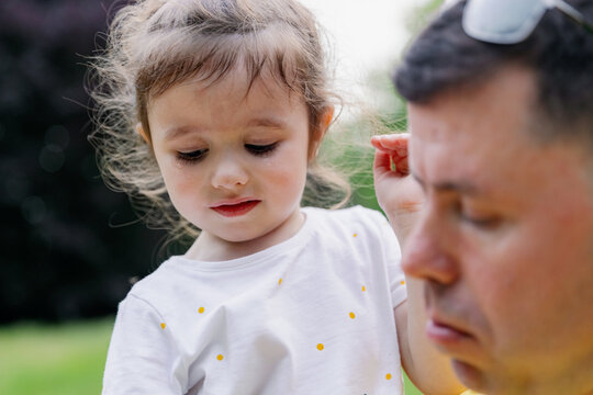 One little girl crying in her father's arms.