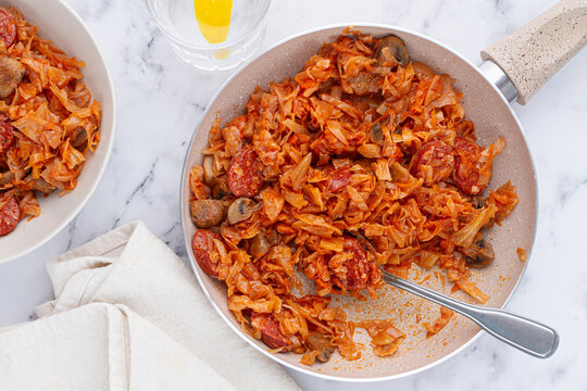 Bigos, Polish dish bigos, on the table, pan with stewed meat, with cabbage, chorizo sausages, mushrooms, homemade, without people,