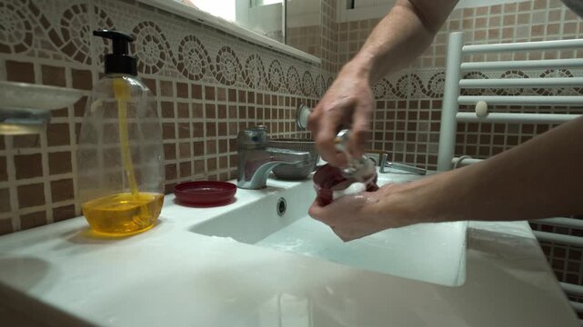 Man Prepares Shaving Lather in Bathroom Sink for Daily Grooming Routine