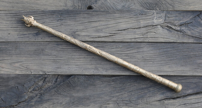 ancient golden magic staff on wooden background