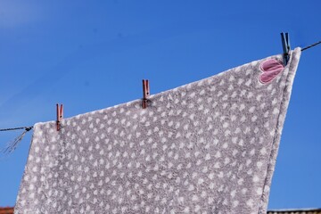 Mały kocyk dziecięcy suszy się na powietrzu © Adam