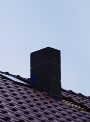 Zacieniony komin na dachu © Adam