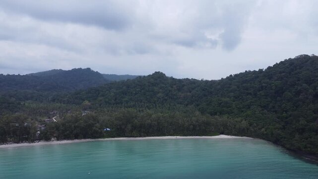 Drone footage capturing the pristine coastline of We Ao Park Bay and Beach on Koh Kood island, Thailand. Turquoise waters, white sand and lush tropical jungle.