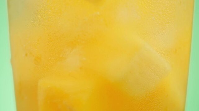 Extreme Macro Close-up of Cold Pineapple Drink with Ice and Fresh Fruit Slices on Green Background, Food Ads
