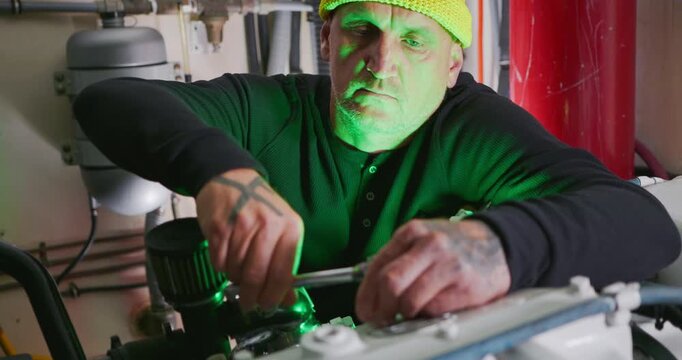 Technician Adjusting Machinery in Engine Room