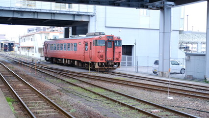 Fototapeta premium Vintage Red Japanese Diesel Locomotive Train on Tracks at Urban Station