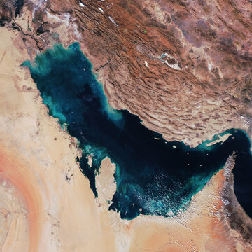 satellite top view of the Persian Gulf, showcasing the contrast between deep blue waters, rugged brown mountain ranges of Iran, and the vast sands of the Arabian Peninsula. image furnished by NASA