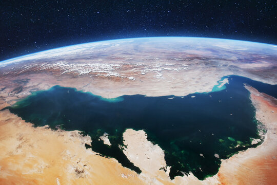 High-altitude satellite view of the Persian Gulf and Arabian Peninsula under a starry space background. Earth curve reveals desert landscapes, turquoise coastal waters, and distant mountain ranges