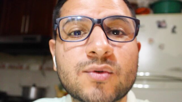 Portrait of a Hispanic man with glasses speaking to a camera inside his home in Bosa, Bogot&aacute;, Colombia. Concept of user-generated content and Colombian people