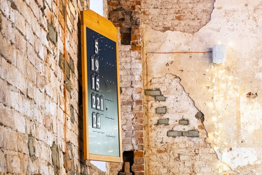 Church hymn board on an old brick wall.