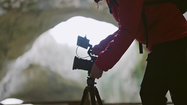 Adventurer Videographer Prepares Camera in Mysterious Cave