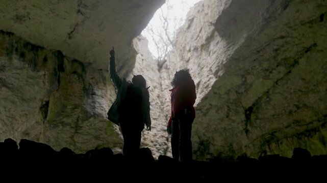 Devetashka Cave Wonders: Silhouetted Women Pointing to Light