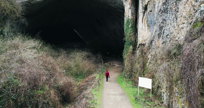 Devetashka Cave Entrance: Man Explores Ancient Wonder from Above