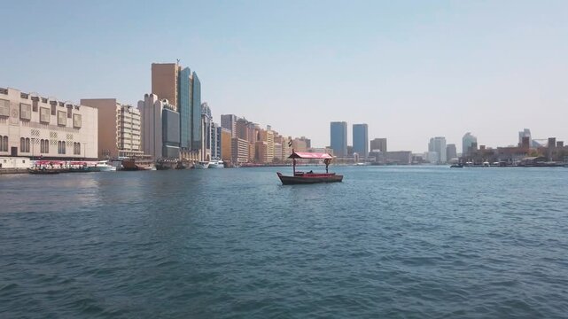 Traditional Abra Boat Navigates Dubai Creek with Iconic City Skyline View