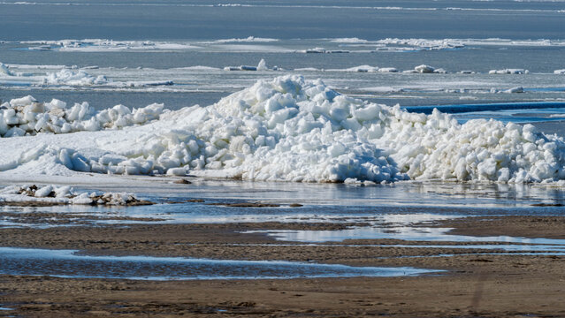 Massive ice hummocks on a sandy beach in spring
