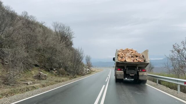 Heavy Haul: Dump Truck Transporting Rocks on Mountain Road